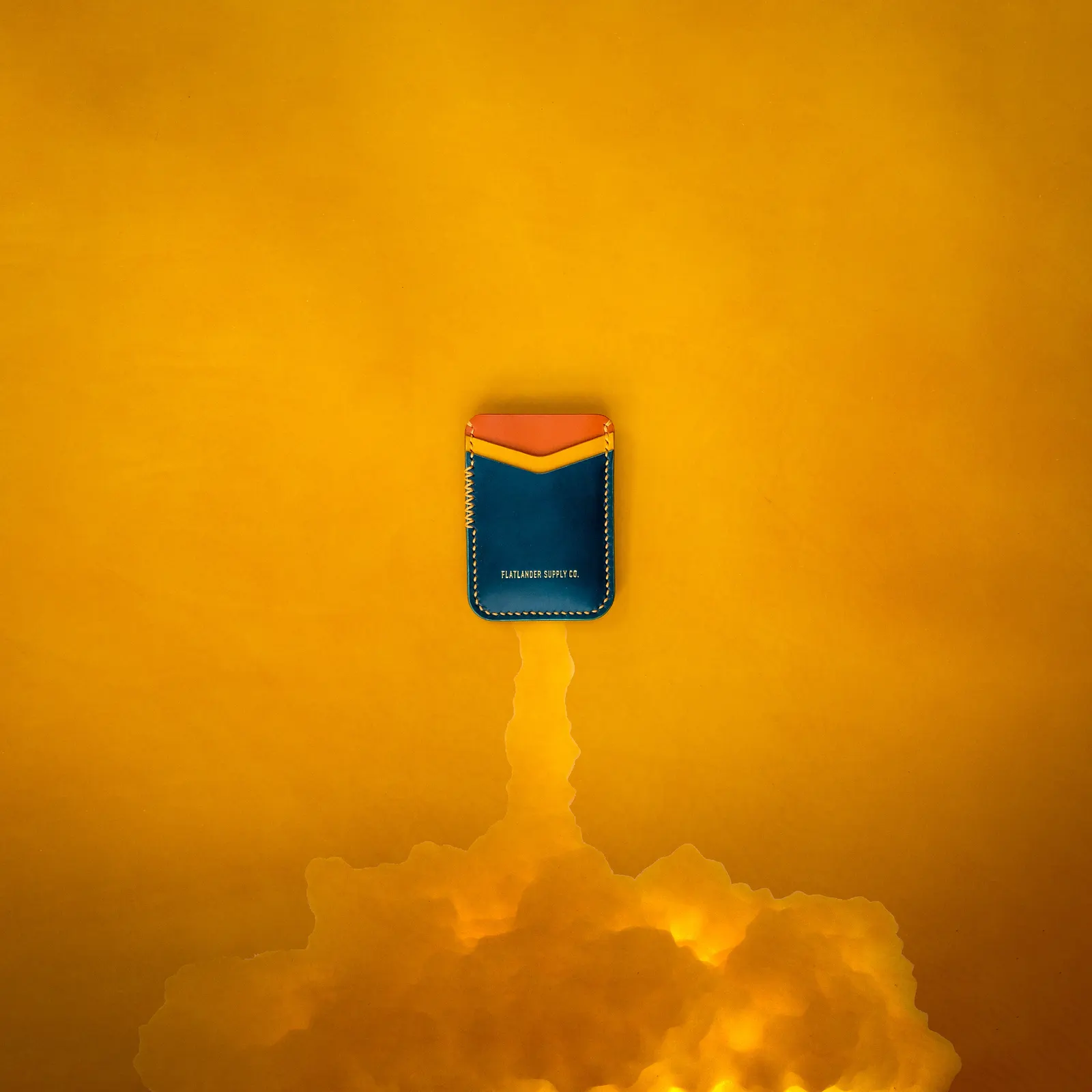 A navy card sleeve suspended above a plume of yellow smoke on a yellow backdrop